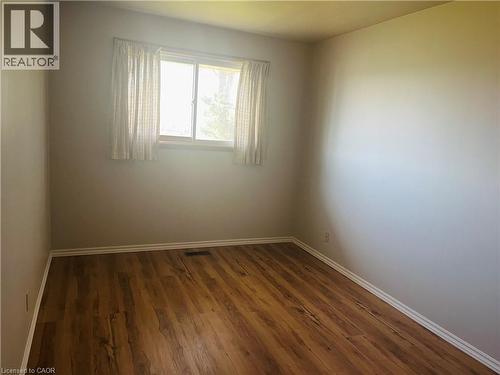 Neutral tone walls complement wood-finish flooring - 157 Schweitzer Street, Kitchener, ON - Indoor Photo Showing Other Room