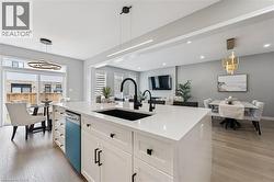 Kitchen island featuring a black sink and faucet, white cabinetry with black hardware, and light-colored countertops - 
