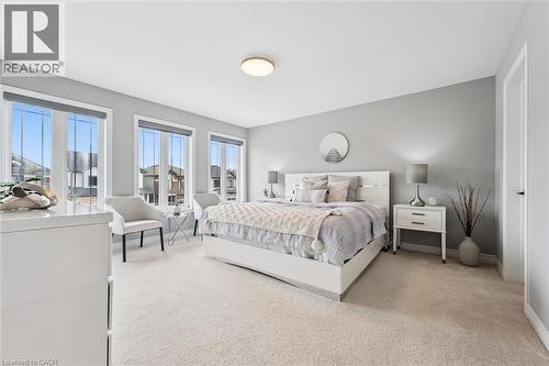 Light-filled room featuring three large windows with roller shades, neutral carpeting, and light gray wall paint - 628 Florencedale Crescent, Kitchener, ON 