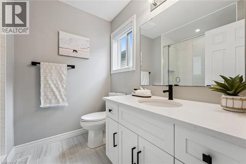 Contemporary bathroom featuring a white vanity with a single sink, light-toned countertop, and matte black fixtures - 628 Florencedale Crescent, Kitchener, ON 