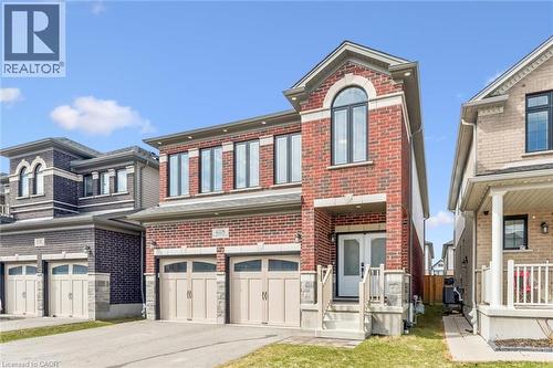 Brick facade residence with a two-car garage, covered porch entry, arched upper window, and a concrete driveway - 628 Florencedale Crescent, Kitchener, ON 