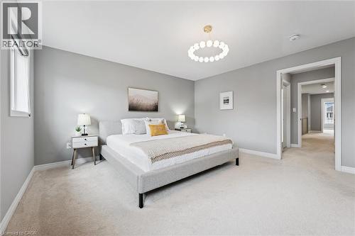 Bedroom featuring light gray walls, plush carpet flooring, and a modern circular ceiling light fixture - 628 Florencedale Crescent, Kitchener, ON 