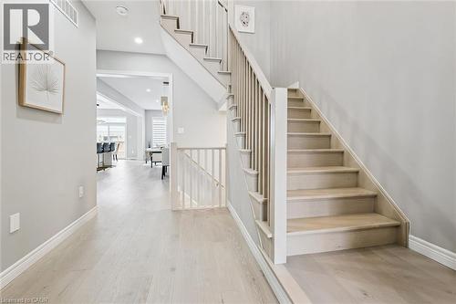 Light wood-finish flooring extending through the hallway and staircase - 628 Florencedale Crescent, Kitchener, ON 