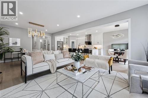 Open-concept living area with light wood-finish flooring, recessed lighting, and a contemporary chandelier - 628 Florencedale Crescent, Kitchener, ON 