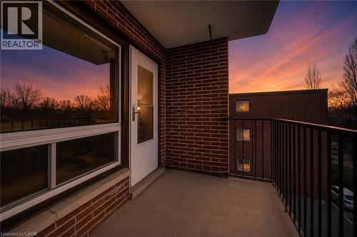 Concrete balcony with a black metal railing and brick exterior - 303-4 Avalon Place, Kitchener, ON - Outdoor With Balcony With Exterior