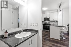 Bathroom with wood finished floors, decorative backsplash, and vanity - 