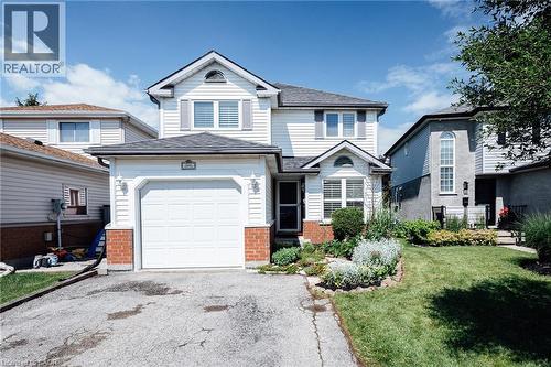 Two-story residence featuring white siding, a single-car garage, and a peaked roofline - 560 Penny Lane, Waterloo, ON 