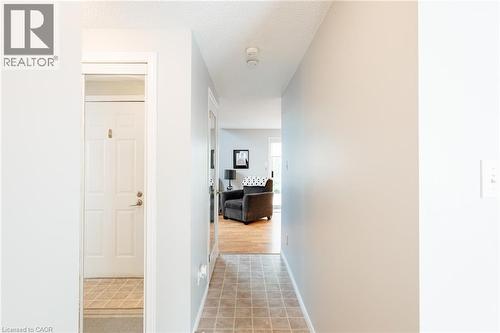 Hallway featuring neutral wall colors, textured ceiling, and tiled flooring - 560 Penny Lane, Waterloo, ON 