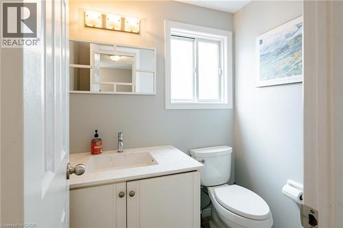 Bathroom featuring a white vanity with an integrated sink, a light-colored countertop, and a chrome faucet - 560 Penny Lane, Waterloo, ON 