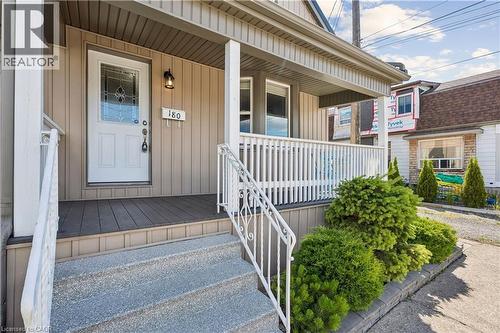 Covered front porch featuring vertical siding and composite decking - 180 Campbell Avenue, Hamilton, ON - Outdoor With Deck Patio Veranda