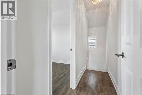 Interior hallway with wood-finish flooring, white painted walls, and white trim - 180 Campbell Avenue, Hamilton, ON - Indoor Photo Showing Other Room