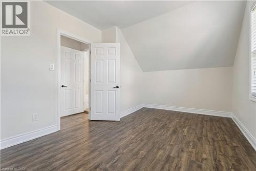 Room featuring wood-finish flooring, white baseboards, and a sloped ceiling - 180 Campbell Avenue, Hamilton, ON - Indoor Photo Showing Other Room