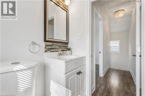 Contemporary bathroom vanity featuring a rectangular under-mount sink, chrome faucet, and white countertop - 180 Campbell Avenue, Hamilton, ON - Indoor Photo Showing Other Room