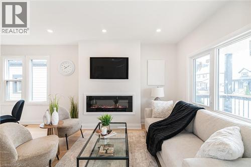Living area featuring an integrated electric fireplace, recessed lighting, and large windows - 297 Britannia Avenue, Hamilton, ON 