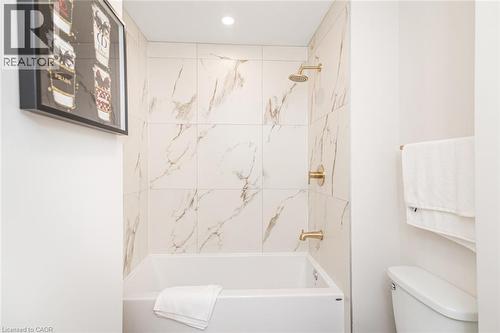 Bathtub with a white surround and polished brass fixtures - 297 Britannia Avenue, Hamilton, ON 