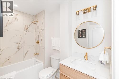 Bathroom featuring a bathtub with a shower, a toilet, and a vanity - 297 Britannia Avenue, Hamilton, ON 