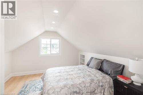 Attic room featuring a single window, recessed lighting, built-in shelving, light wood-finish flooring, and white baseboards - 297 Britannia Avenue, Hamilton, ON 
