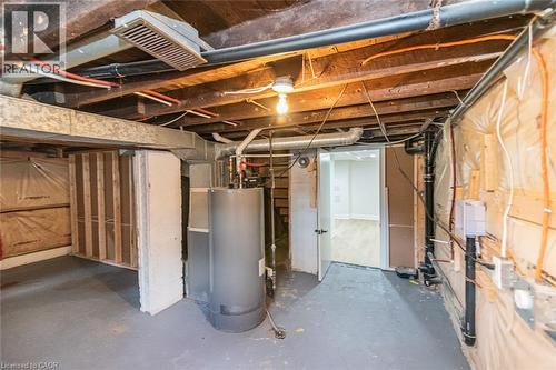 Unfinished basement space featuring exposed wooden ceiling joists, visible HVAC ductwork, and utility piping - 297 Britannia Avenue, Hamilton, ON 