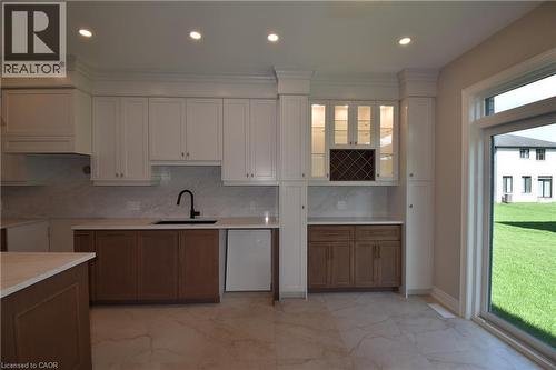 Modern kitchen featuring recessed ceiling lighting, two-tone cabinetry, light-toned countertops, and a full-height tile backsplash - 8 Dunlop Road, Hamilton, ON - Indoor Photo Showing Kitchen