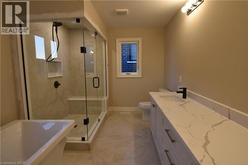 Spa-inspired primary bathroom featuring a frameless glass-enclosed shower with marble-look surround, freestanding soaking tub, dual-sink vanity with quartz countertop and matte black hardware, heated - 8 Dunlop Road, Hamilton, ON - Indoor Photo Showing Bathroom