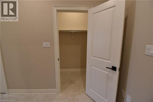 Spacious walk-in closet featuring built-in shelving, a hanging rod for full-length garments, and neutral finishes throughout - 8 Dunlop Road, Hamilton, ON - Indoor Photo Showing Other Room