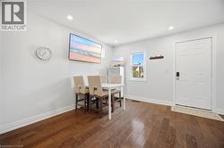 Bright interior space featuring rich wood-finish flooring, recessed lighting, and a white paneled entry door - 