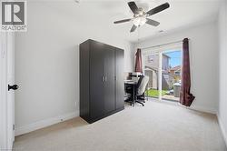Room featuring light-colored carpeting, white walls, and a ceiling fan with integrated lighting - 