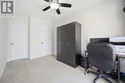 Neutral toned room featuring light-colored carpeting, white walls, and a ceiling fan with integrated lighting - 