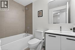 Full bathroom featuring a white tub with chrome fixtures, a wall-mounted showerhead, and a tiled shower surround - 