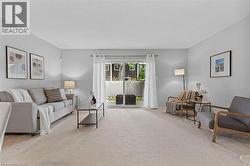Living area featuring light-colored carpeting, light gray walls, and white trim - 