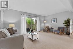 Living area featuring light neutral wall tones and carpet flooring - 