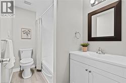 Bathroom featuring a white vanity with integrated sink, chrome faucet, and framed mirror - 