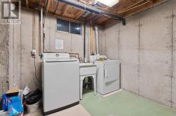 Laundry area featuring a top-load washing machine, a front-load dryer, and a utility sink - 