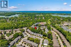 Aerial perspective showcasing a residential community with abundant mature trees and proximity to a large body of water - 
