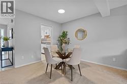 Recessed ceiling lighting illuminates a carpeted dining area with light gray walls and white trim - 
