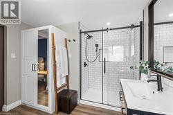 Modern bathroom featuring a glass-enclosed shower with subway tile surround, matte black fixtures, and a built-in shower niche - 
