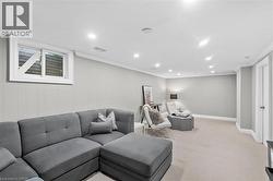 Finished lower level featuring recessed lighting, paneled accent wall, a window, neutral carpeting, and white trim - 