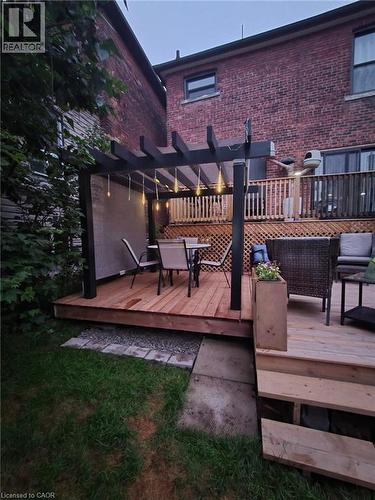 Expansive backyard featuring a multi-level wooden deck with a black pergola - 361 Cumberland Avenue, Hamilton, ON 