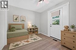 Bedroom with wood-finish flooring and light gray walls - 