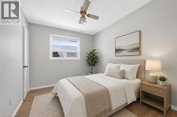 Light-filled interior featuring wood-finish flooring, a ceiling fan, and crisp white trim - 