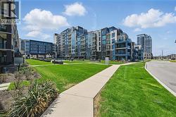 Modern multi-story buildings featuring balconies and a central green space - 
