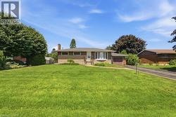 Ranch-style residence featuring a brick and siding exterior, an attached single-car garage, and a paved driveway - 