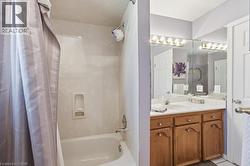 Dual vanity with integrated sinks, wood-finish cabinetry, and a full-width mirror - 