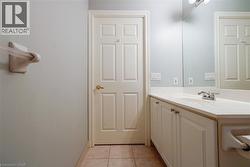 Bathroom featuring a white vanity with an integrated sink, polished chrome faucet, and a wall-mounted mirror - 