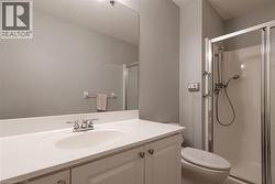 Bathroom featuring a white vanity with an integrated sink, chrome faucet, and a large wall-mounted mirror - 