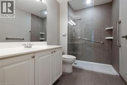 Modern bathroom featuring a glass-enclosed shower with gray tiled walls - 