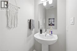 Pedestal sink with chrome faucet, large vanity mirror, and overhead light fixture - 