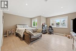 Spacious bedroom featuring light-toned wood-finish flooring, recessed lighting, and neutral wall tones - 