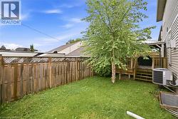 Expansive backyard featuring a manicured lawn, a privacy fence with lattice detailing, and a multi-level wood deck - 
