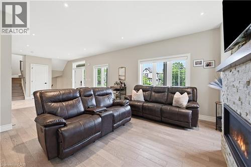 Living area featuring light wood-finish flooring, recessed lighting, and a stone-clad fireplace with an integrated firebox - 1 Lindsay Way, Grimsby, ON - Indoor Photo Showing Living Room With Fireplace